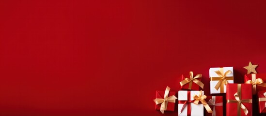Banner with many gift boxes tied velvet ribbons and paper decorations on red background. Christmas background, copy space