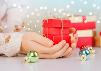 Close up of children hands holding Christmas  present. Children hands holding gift box 
