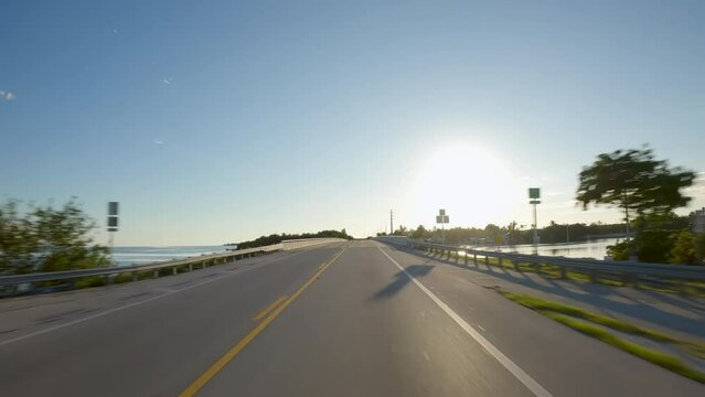 POV Driving a car towards sunset on Florida Keys Overseas Highway connecting tropical islands