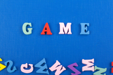 GAME word on blue background composed from colorful abc alphabet block wooden letters, copy space for ad text. Learning english concept.