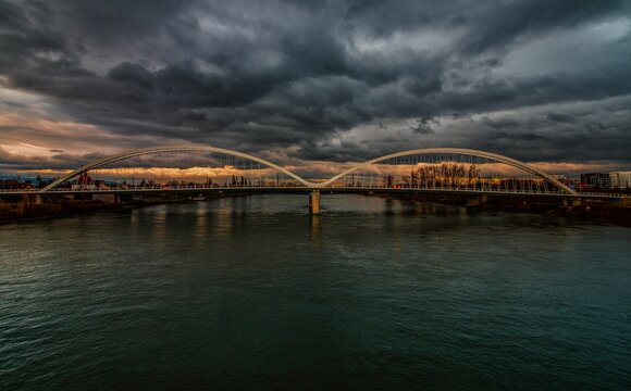 Scenic view of a bridge over a river at a cloudy sunset