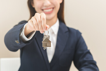 Close up hand of home, apartment agent, woman realtor  holding key to new landlord, tenant or rental after banker approved and signed on contract purchase agreement successfully. Property concept.
