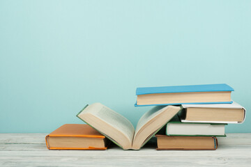 Open book, hardback colorful books on wooden table. Back to school. Copy space for text. Education business concept.