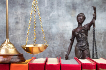 Law concept - Open law book scales, Themis statue on table in a courtroom or law enforcement office.