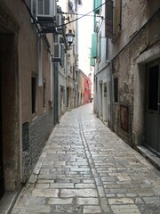 Fototapeta na wymiar Picturesque alleyway between two buildings in a town or city, leading into the unknown