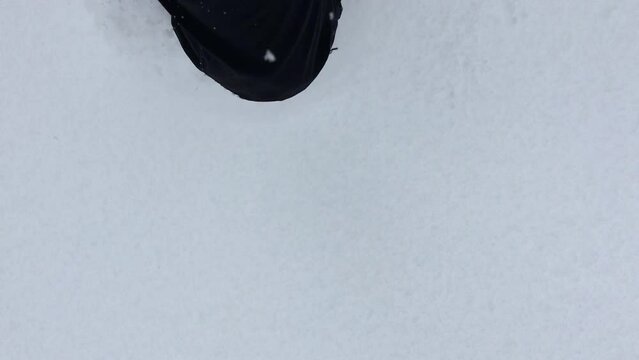 Top view of a person walking in the big layer of white snow