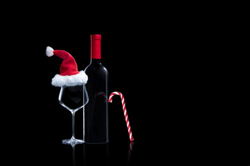 Bottle of wine with glass in the Christmas style on a black background
