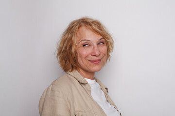 Cheerful smiling woman looking back on white color background