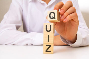 businessman holding wooden cubes with QUIZ text
