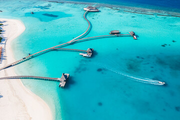 Tranquil aerial landscape, luxury tropical resort water villas. Beautiful island beach palm trees sunny sea sky. Amazing bird eyes panoramic Maldives paradise coast. Exotic vacation travel destination