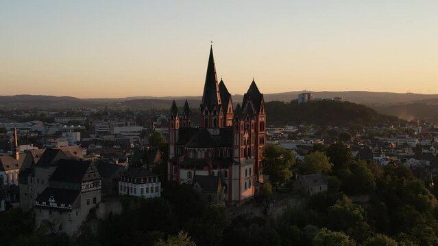 Drone view over the Limburg Cathedral surrounded by cityscape during sunset