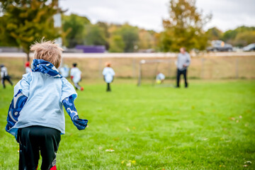 Child on the sidelines cheering on his soccer team.
