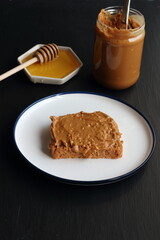 Peanut butter sandwich with honey on a black background