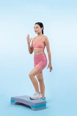 Vigorous energetic woman doing exercise at on studio short isolated background with cardio aerobic step workout. Young athletic asian woman dexterity and endurance training session concept.