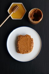 Peanut butter sandwich with honey on a black background