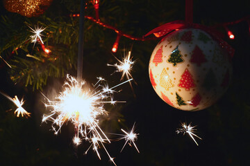 Sparkler burning on a Christmas tree.Christmas tree decoration and sparkler close-up