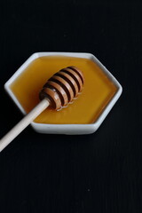 Fresh Honey with wooden honey spoon on a black background