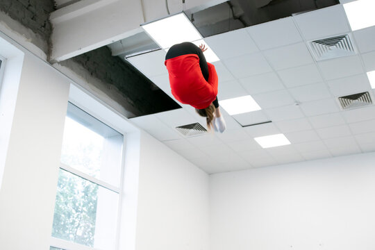 girl doing aerial acrobatics on trampolines, doing exercises in the sports center - Powered by Adobe