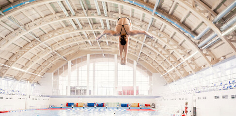 sports diving, an athlete doing a somersault, jumping from a springboard into the pool