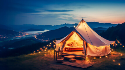 Luxury glamping camping tent with cozy accessories, light garlands and beautiful landscape at sunset. Warm cozy light inside camp tent. Millennial trend vacation destination. Staycation in mountain - obrazy, fototapety, plakaty