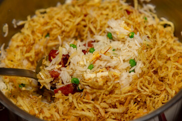 Traditional biro biro rice with peas, bacon, egg, straw potatoes and aromatic herbs