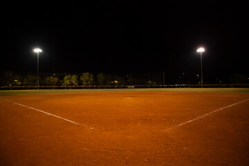 Empty baseball field at night, view from home plate