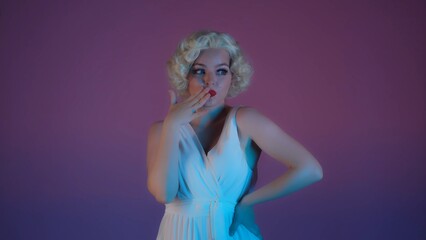 Portrait of a charming woman in the image of close up. Woman with bright makeup in white dress and wig in studio in pink and green neon light.