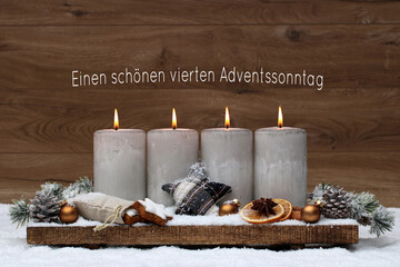 Vierter Advent: Adventsdekoration mit vier brennenden vor einem braunen Holzhintergrund. Mit dem...