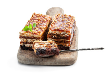 Layered cake with caramel cream and nuts isolated on white