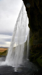 behind the water curtain of seljalandsfoss in southern iceland