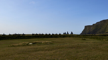 horse riding in front of Reynisdrangar in Vik, Iceland