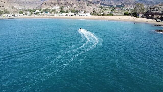 unrecognizable people on jetsky and a few boats