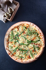 Delicious pizza with pears and gorgonzola cheese. View from above. Arugula on top of pizza.