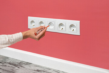 Man is checking the electrical outlet.