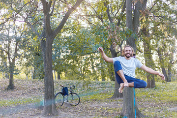 A Man Balances On Slackline In A Park