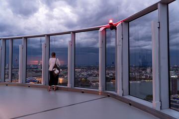 woman looks at the city of Cologne from the Cologne Triangle observation deck