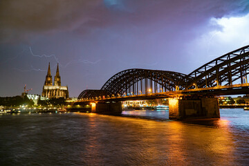Fototapeta premium Lightning and dramatic storm clouds over Cologne Cathedral and Hohenzollern Bridge
