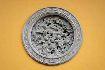 A circular marble medallion with carved lions on a wall outside a building