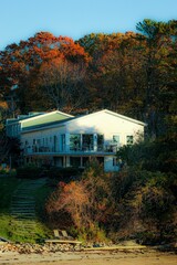 Fototapeta na wymiar Cozy home on Peaks Island, Maine, overlooking the shoreline and surrounded by autumn foliage.