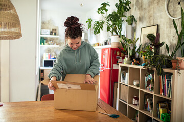 Young woman unpacking box in the kitchen