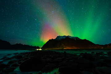 Awesome Northern lights over the snowy mountains. Lofoten islands, Norway.