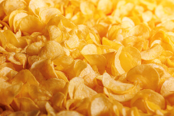 Fresh Crispy potato chips snack texture background with sun light, top view