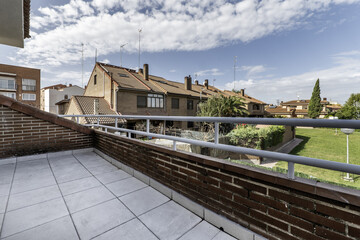Fototapeta na wymiar Small terrace with white railing in a single-family home with views of common areas with swimming pool and gardens with lots of grass