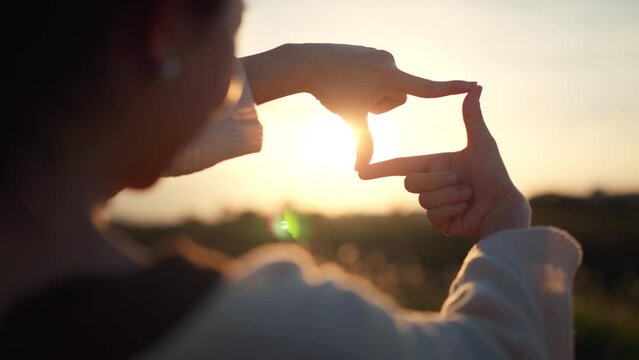 B roll - travel freedom a concept, Close up of traveler woman hands making frame gesture with sunset in summer, Female capturing the sunrise