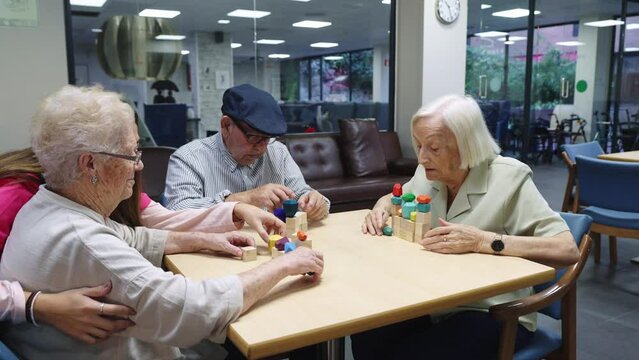 Old people and nurse playing skill brain games