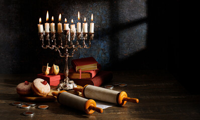 Hanukkah (traditional candelabra), doughnut, dreidel, Religious books (Tanakh) and scroll Tanakh on a dark background