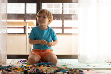 Little boy play at his home near window