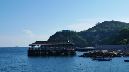 Group of individuals on a wooden pier overlooking a tranquil sea