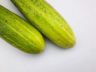 2 cucumbers isolated on a white background, this fruit contains a lot of water so it is very refreshing but tastes bland, can be eaten directly or cooked, often also used as a garnish or facial mask