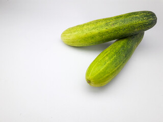 2 cucumbers isolated on a white background, this fruit contains a lot of water so it is very refreshing but tastes bland, can be eaten directly or cooked, often also used as a garnish or facial mask